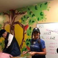 A volunteer smiles for a photo while packing food at Kids' Food Basket in Muskegon.